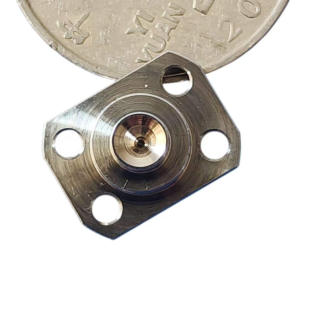 Precision metal component with coin for size reference, high-precision custom machining